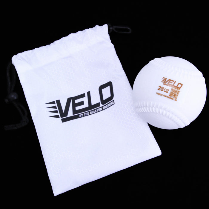 A white VELO branded drawstring carrying bag with a white weighted training ball labeled 'VELO 28oz' displayed alongside.
