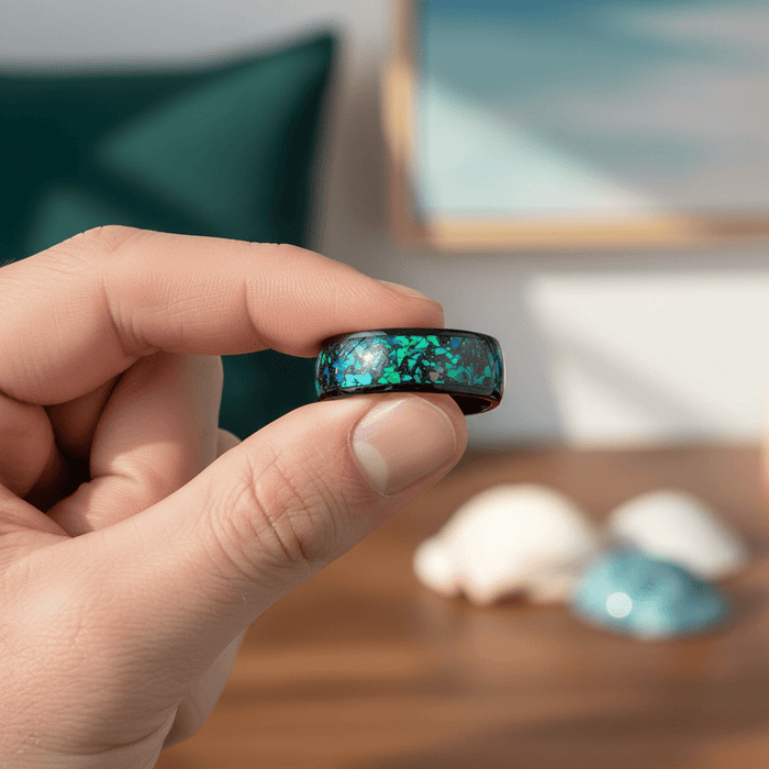 ZURLOU — Held between fingers close-up — men's tungsten wedding ring.